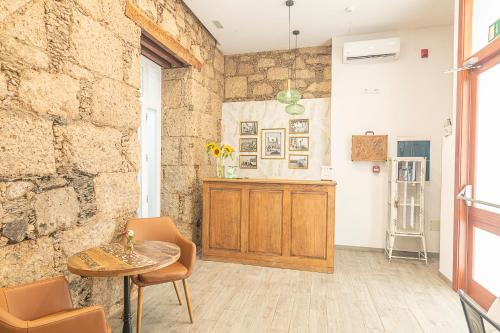 a room with a table and chairs and a stone wall at Hotel The Cathedral Vegueta in Las Palmas de Gran Canaria