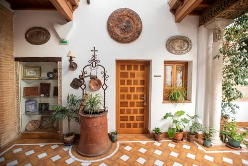 una puerta delantera de una casa con macetas en La Llave de la Judería Hotel Boutique, en Córdoba