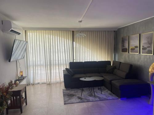 uma sala de estar com um sofá e uma mesa em Llalis luxury em Eilat