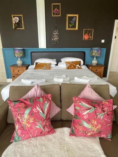 a bedroom with a large bed with pink pillows at The Sheldon B&B - FREE private parking in Eastbourne