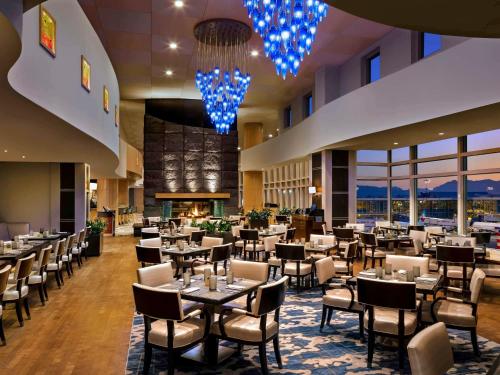 a restaurant with tables and chairs in a hotel lobby at Fairmont Vancouver Airport In-Terminal Hotel in Richmond