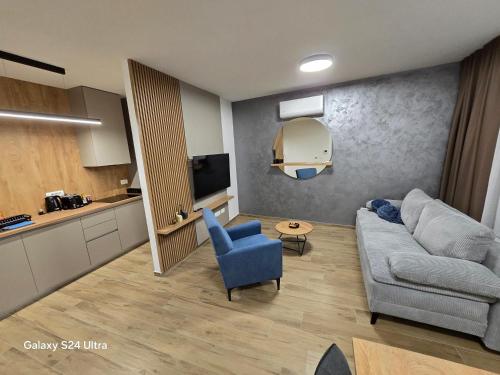 a living room with a couch and a blue chair at Apartman AURA self CHECK-IN, FREE PRIVATE PARKING in Osijek