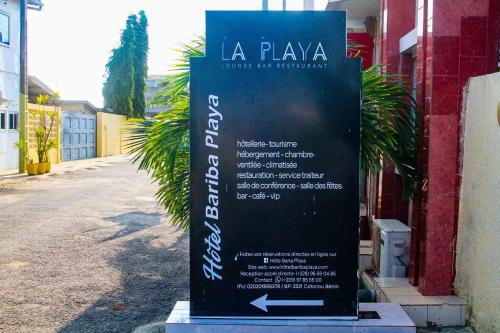 una señal que está sentada fuera de un edificio en Hotel Bariba playa, en Cotonou