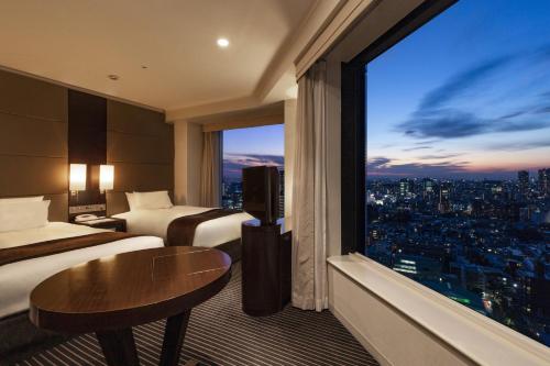 Habitación de hotel con 2 camas y ventana grande. en Shinagawa Prince Hotel, en Tokio