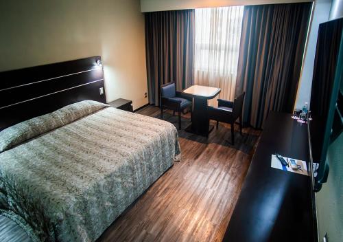 a hotel room with a bed and a desk at Hotel Parque Satelite in Mexico City