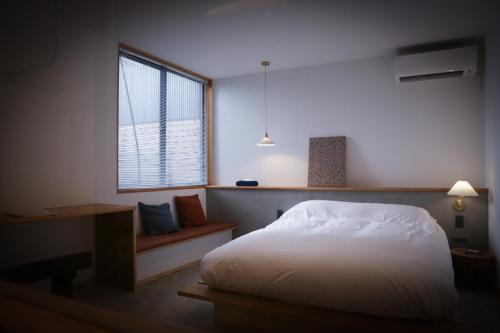 una camera con un letto bianco e una finestra di Lemonsea Onomichi a Onomichi