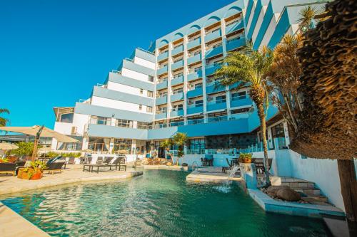 um hotel com piscina em frente a um edifício em Hotel Villareal São Francisco do Sul em São Francisco do Sul