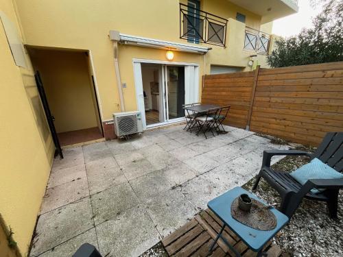 eine Terrasse mit 2 Stühlen und einem Tisch vor einem Haus in der Unterkunft Le Relais de la Calèche in Le Beausset