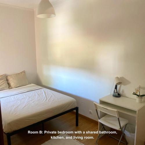 a bedroom with a bed and a desk with a lamp at Lisbon Airport Guesthouse in Lisbon