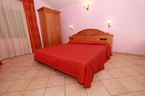 a bedroom with a bed with a redspread on it at Hotel Canada in Falerna Marina