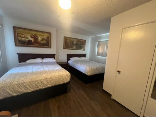 - une chambre d'hôtel avec 2 lits et une porte dans l'établissement Flamingo Motel - San Ysidro, à San Diego