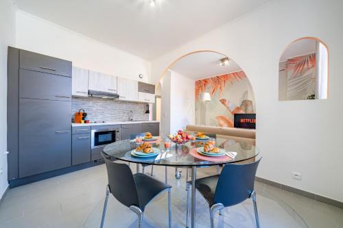 cocina y comedor con mesa de cristal y sillas en 1Br - Monaco 1 Min Walk - Close to Port and Train, en Beausoleil