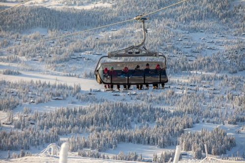 a group of people sitting on a ski lift at Skeikampen Booking in Svingvoll