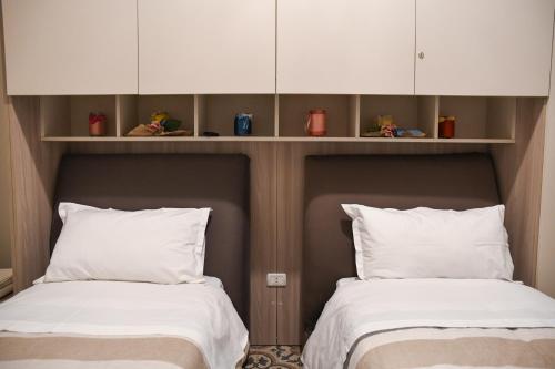 two beds sitting next to each other in a room at Xenia Home in Reggio di Calabria