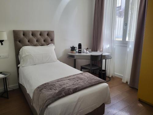 a bedroom with a bed and a small table at Sempione Boutique Hotel in Stresa