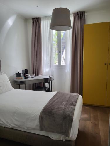 a bedroom with a bed and a table and a window at Sempione Boutique Hotel in Stresa