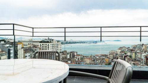 a table and chairs on a balcony with a view of the city at Sofitel Istanbul Taksim in Istanbul