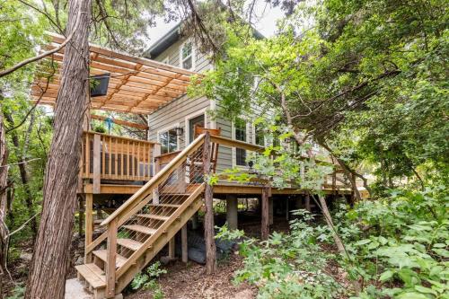 a house in the woods with a wooden deck at Cozy Coop Casita - Lake Travis-Hot Tub-Tiny House in Austin