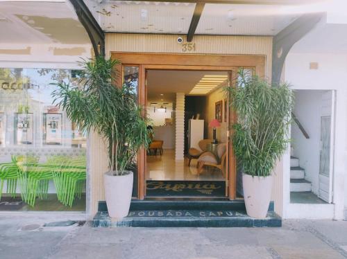 a store front with two potted plants in front of it at Pousada Capua Buzios in Búzios