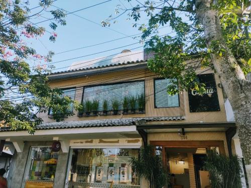 a building with a balcony with plants on it at Pousada Capua Buzios in Búzios