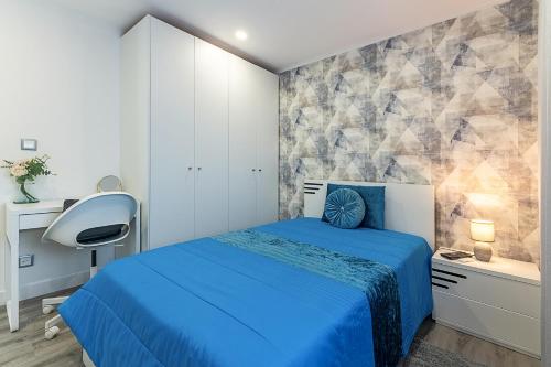 a bedroom with a blue bed and a chair at MyPlaceLisbon - Lumiar Luxury House in Lisbon