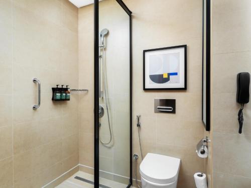 a bathroom with a shower and a toilet at voco Jeddah Gate, an IHG Hotel in Jeddah