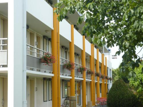 a large white building with yellow columns at Premiere Classe Strasbourg Ouest in Strasbourg