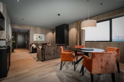 a living room with a table and chairs and a couch at Pellestova Hotell Hafjell in Hafjell