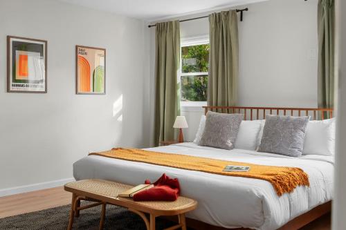 a bedroom with a bed with a red pillow on it at Retro Revival - Mid-Century Refuge with a '70s Twist in Alachua