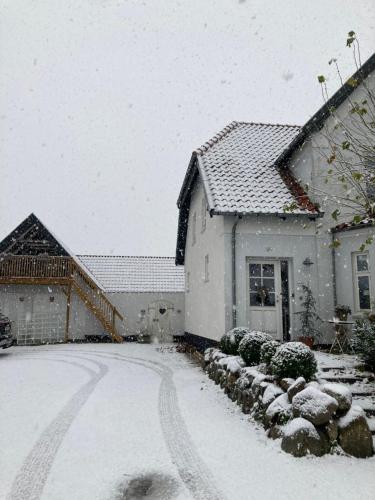 ein schneebedecktes Haus mit Auffahrt in der Unterkunft Marielyst B&B - Apartments in Næstved