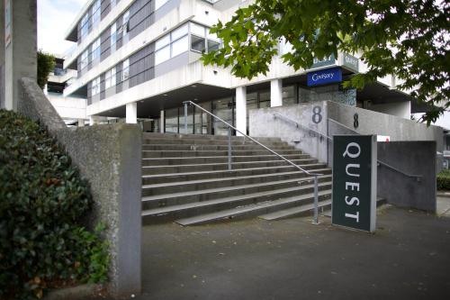 a parking sign in front of a building with stairs at Quest Parnell Serviced Apartments in Auckland