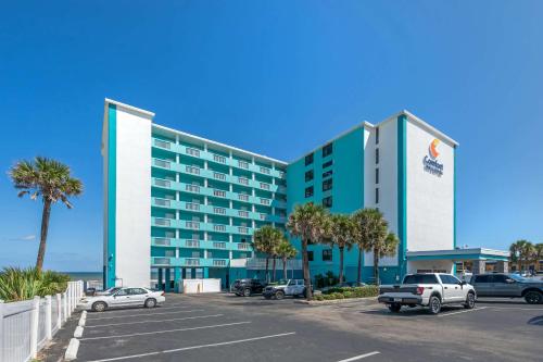 un hotel con coches estacionados en un estacionamiento en Comfort Inn & Suites Daytona Beach Oceanfront, en Daytona Beach