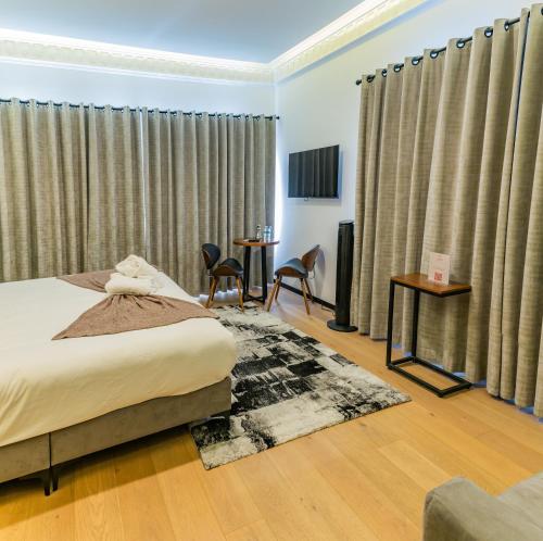 a bedroom with a bed and chairs and curtains at Casa Castillo in Mexico City