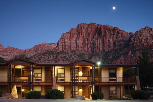 a building with a mountain in the background at The Red Cliffs Lodge Zion, a Tribute Portfolio Hotel in Springdale