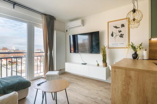 a living room with a large window and a couch at Apartment Oasis in Osijek