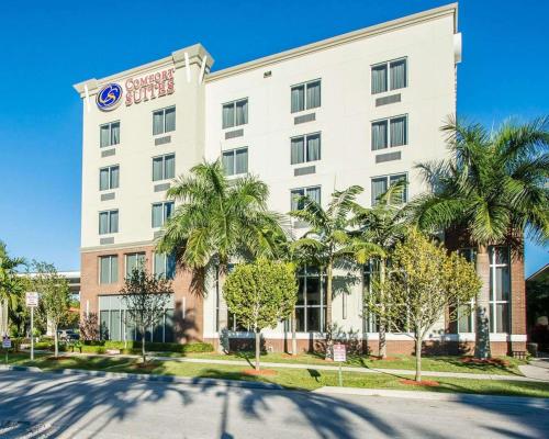 een hotel met palmbomen voor een gebouw bij Comfort Suites Miami Airport North in Miami