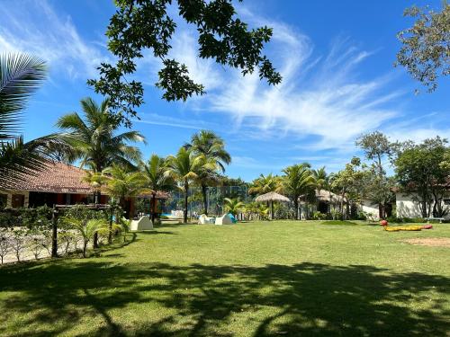 a park with palm trees and a blue sky at Acquamarine Park Hotel in Guarapari