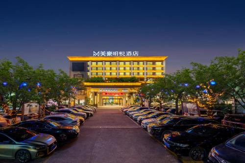 een parkeerplaats met auto's voor een gebouw bij Pazhou Mingyue Resort Hotel Canton Fair Complex Branch in Guangzhou