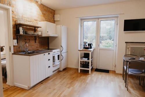 a kitchen with a white refrigerator and a table at Vassbo Vandrarhem in Falun