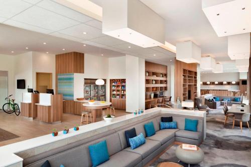 een lobby met een bank en stoelen en een bibliotheek bij Element Dallas Love Field in Dallas