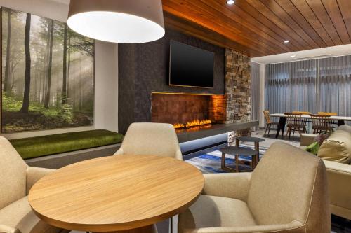 a living room with a table and a fireplace at Fairfield by Marriott Inn & Suites Knoxville Airport Alcoa in Alcoa