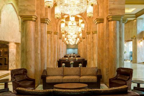 a living room with a couch and a chandelier at Sheraton Kuwait, a Luxury Collection Hotel, Kuwait City in Kuwait