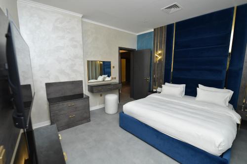 a bedroom with a large bed with a blue headboard at Palazzo hotel in Kuwait