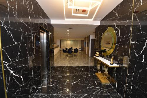 a bathroom with black marble walls and a mirror at Palazzo hotel in Kuwait