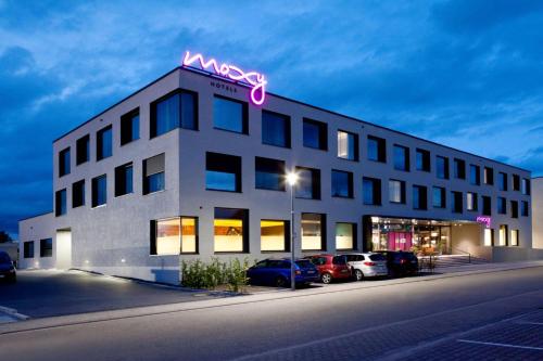 a building with a neon sign on top of it at Moxy Rust in Rust