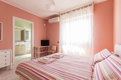 a bedroom with a bed and a large window at B&B Mareya in Cagliari