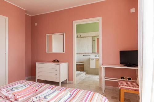 a bedroom with a bed and a dresser and a mirror at B&B Mareya in Cagliari