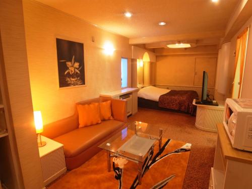 a living room with a couch and a bed at Hotel Plage (Adult Only) in Yokohama