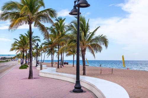 eine Straßenbeleuchtung neben einem Strand mit Palmen in der Unterkunft Ocean Beach Club in Fort Lauderdale