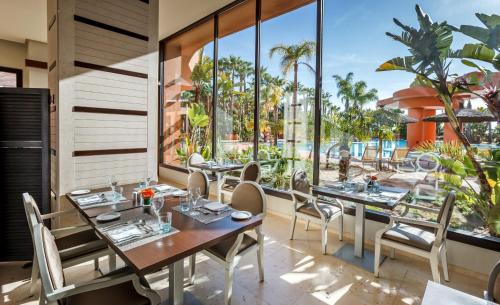 a restaurant with tables and chairs and large windows at Royal Hideaway Sancti Petri in Chiclana de la Frontera